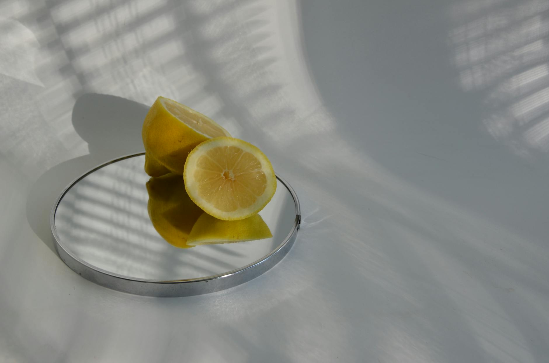 Hand holding a bright lemon against a yellow background, symbolizing vitality and sensual renewal