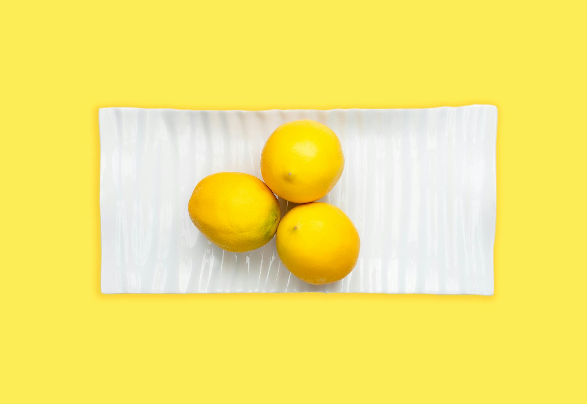 Bright yellow lemons arranged on a pastel green background, symbolizing fresh approaches to sexual wellness with thyroid dysfunction.