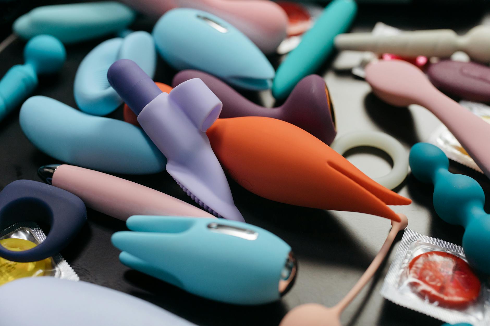 A young couple standing together indoors, holding a blue vibrator, symbolizing reconnection and modern intimacy