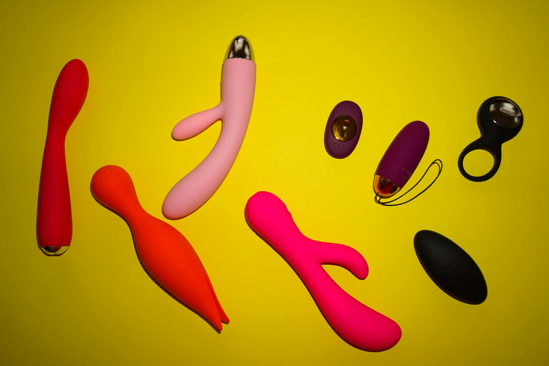 Hands holding a sleek blue vibrator against a purple background