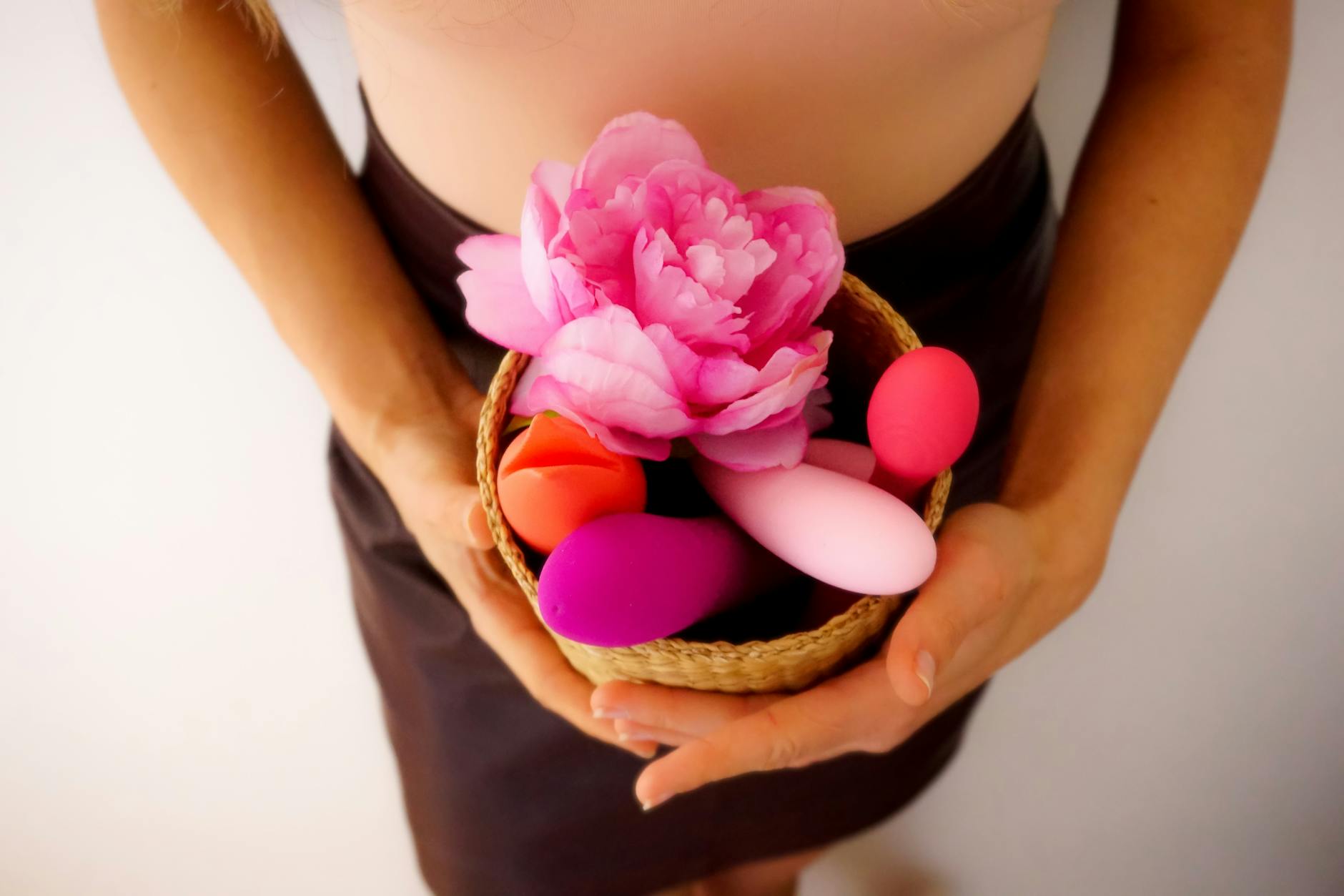 A collection of colorful lemon vibrators and adult toys arranged in a basket with fresh flowers